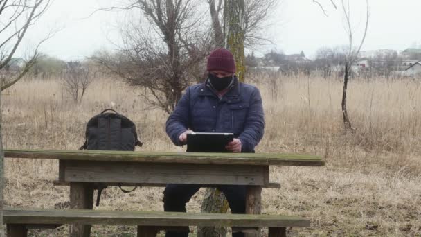 Man Buiten Met Een Tablet Doet Zijn Beschermend Masker — Stockvideo