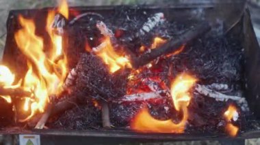  Barbeküde ateşe kuru dallar atmak.