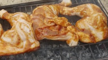 Çiğ tavuk budu ve ketçap ızgarada pişiyor..