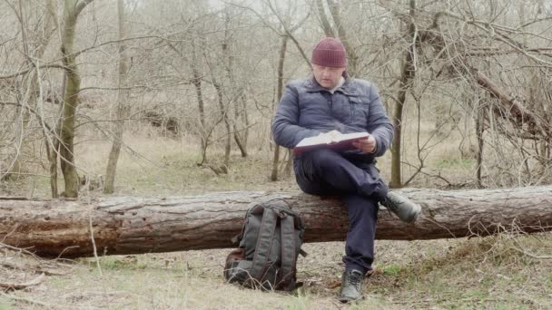 Reiziger Leest Het Rode Boek Het Bos Zittend Een Omgevallen — Stockvideo