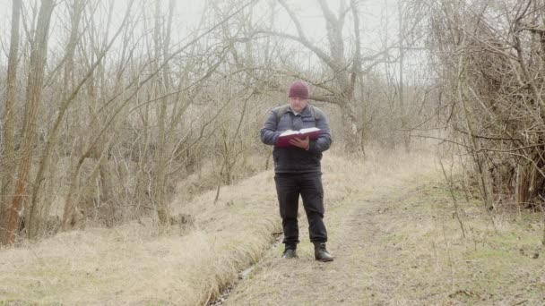 Een Toerist Leest Orthodoxe Bijbel Het Bos Zittend Een Omgevallen — Stockvideo