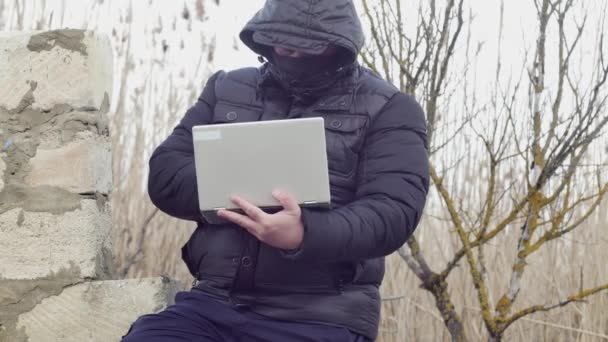 Homem Digitando Laptop Enquanto Sentado Uma Parede Desmoronada — Vídeo de Stock