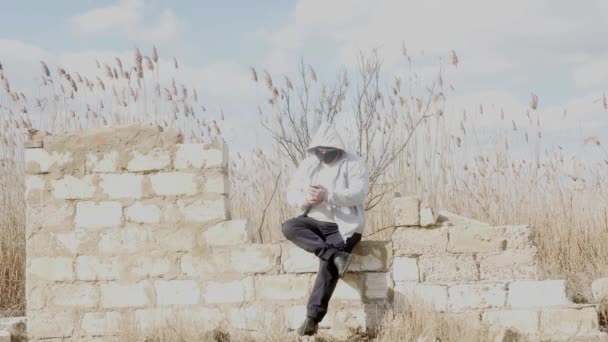 Ein Mann Sitzt Auf Einer Alten Mauerruine Und Schaut Sein — Stockvideo