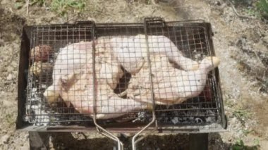  Taze çiğ tavuk bacakları kömürlerin üstünde kızartılıyor..