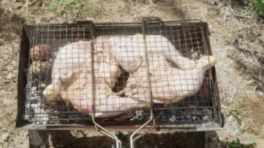 Taze çiğ tavuk bacakları ızgarada pişiyor. Patateslerle birlikte..