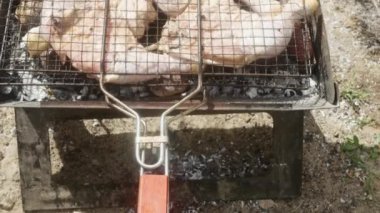  Çiğ tavuk budu ızgarada pişiyor, yanında patates, üst manzara..