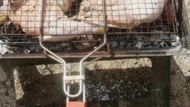 Çiğ tavuk bacağı ve patatesler ızgarada pişirilir. Yakın plan..