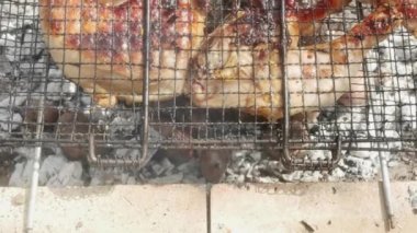 Pembeleşen paslı tavuk bacakları, patatesli sıcak kül üzerinde, yakın plan..