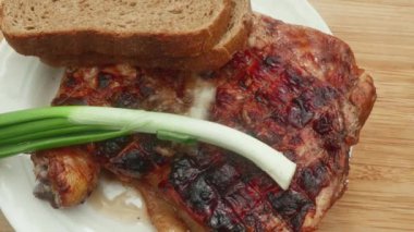 Pırasa, siyah ekmek ve domatesle pişirilmiş tavuk budu, yakın plan.