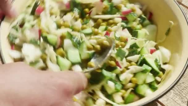 Bir Adamın Eli Kaşıkla Salatayı Konserve Bezelyeyle Karıştırır — Stok video