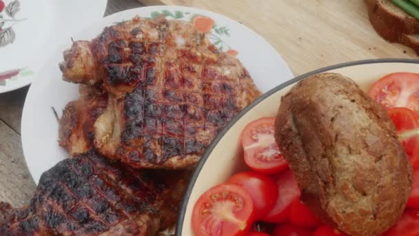Hähnchenkeule Einem Teller Neben Einer Pfanne Mit Frühlingssalat Mit Tomaten — Stockvideo
