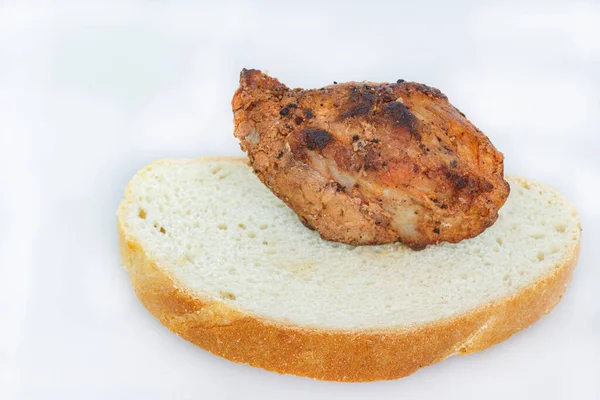 一片面包 上面有一块在火中烹调的猪肉肉 — 图库照片