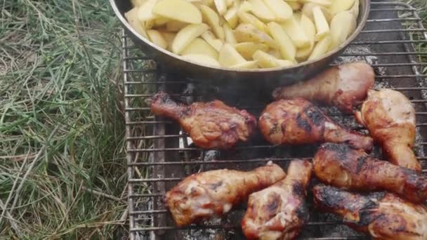 Frying Potatoes Skillet Camping Barbecue Grill Next Chicken Drumsticks — Vídeo de stock