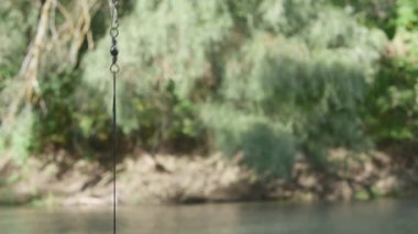 Balık oltasında sallanan balık ve bulanık bir arka planda solucan..