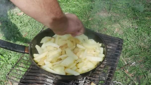 요리하는 사람의 손에는 감자를 숟가락으로 위에서 수있는 프라이팬에 놓는다 — 비디오