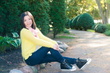 bir yolun yanında oturan kadın