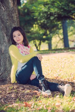 bir ağaç karşı oturan kadın