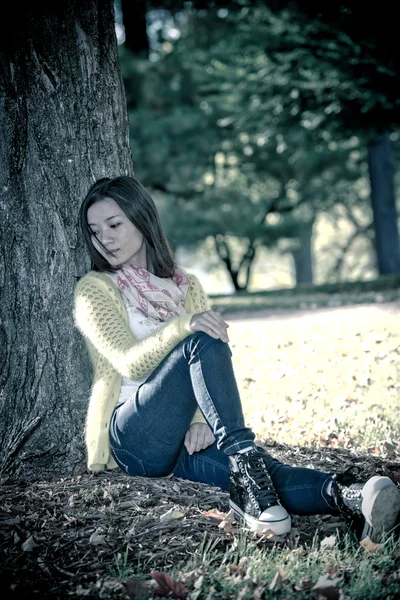 Kobieta siedząca z drzewa — Zdjęcie stockowe