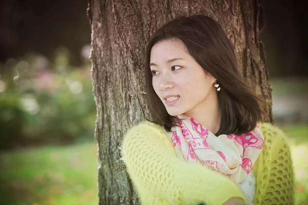 Femme assise contre un arbre — Photo