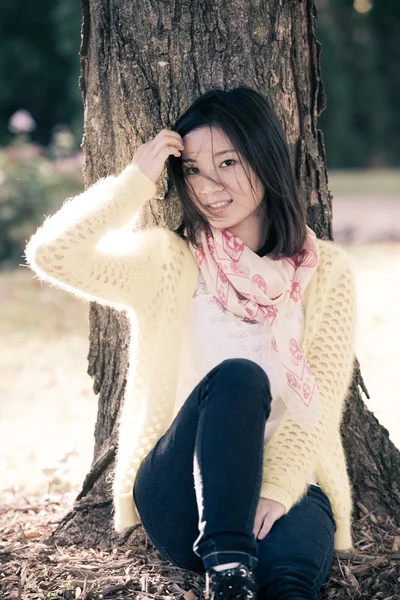 Femme assise contre un arbre — Photo