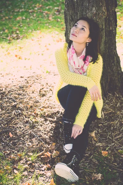 Woman sitting against a tree — Stock Photo, Image