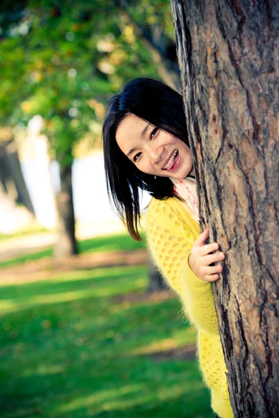 Mujer escondida detrás de un árbol — Foto de Stock
