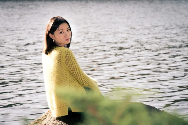 川の隣に座っている女性 — ストック写真