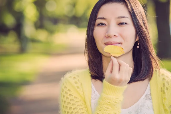 Mujer sosteniendo una hoja verde — Foto de Stock