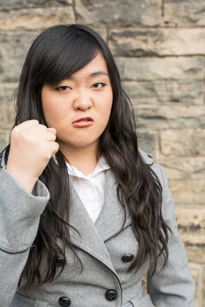 Angry woman by a stone wall — Stock Photo, Image