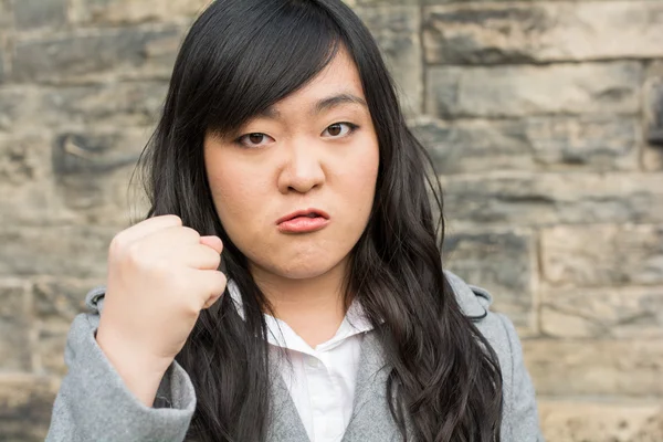 Boos vrouw door een stenen muur — Stockfoto