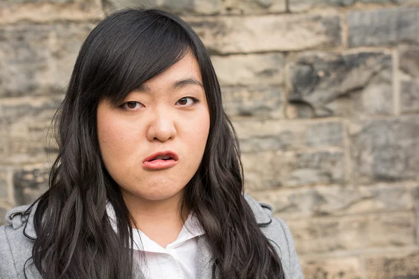 Angry woman by a stone wall — Stock Photo, Image