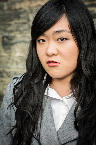 Angry woman by a stone wall — Stock Photo, Image