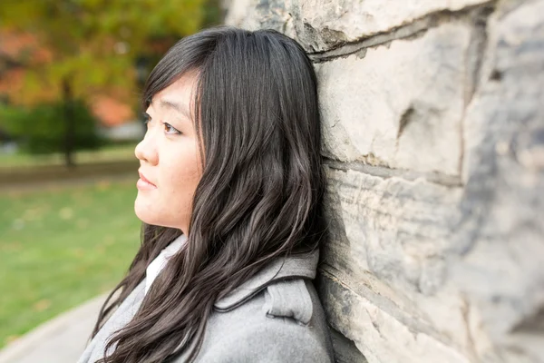 Woman standing against a brick wall — Stock Photo, Image