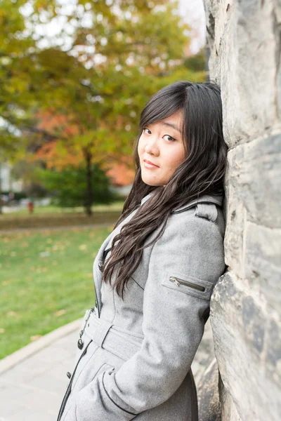 Femme debout contre un mur de briques — Photo