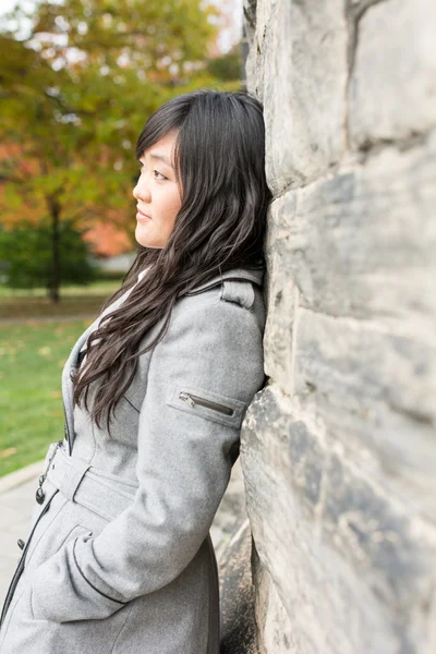 Femme debout contre un mur de briques — Photo