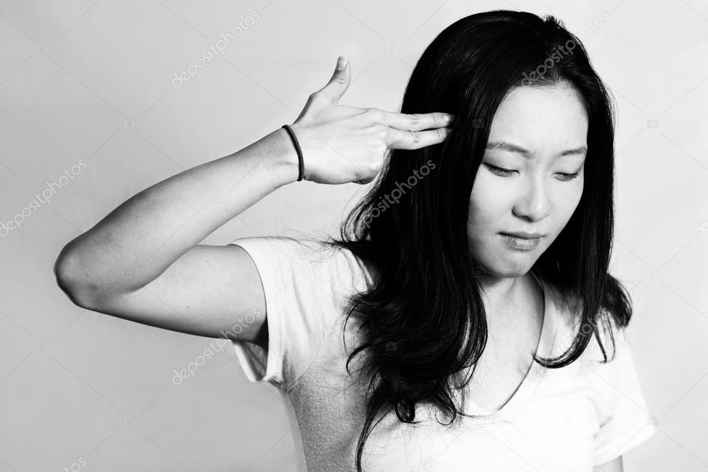 Young woman pointing fingers at her head