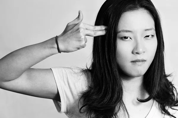 Genç bir kadın onun kafasına parmakları işaret — Stok fotoğraf