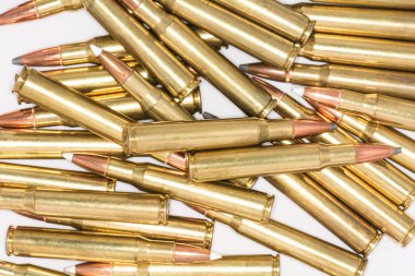 beyaz zemin üzerinde tüfek mermi yığını