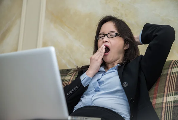 Mujer bostezando en el sofá —  Fotos de Stock