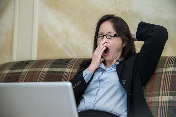 Mujer bostezando en el sofá —  Fotos de Stock