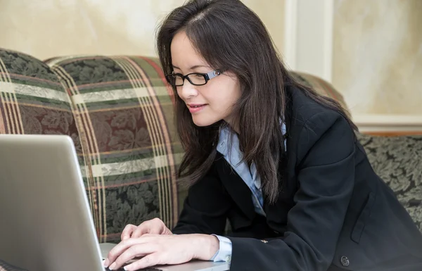 Vrouw die op laptop op Bank te typen — Stockfoto