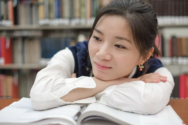 Trött student göra läxor i biblioteket — Stockfoto