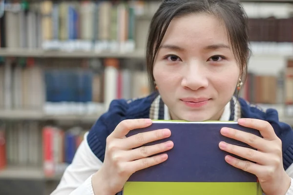 Studentin stützt ihr Kinn auf Lehrbuch — Stockfoto