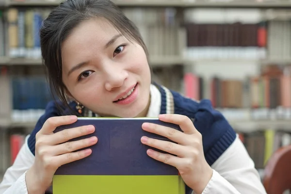 Student rustend haar kin op leerboek — Stockfoto
