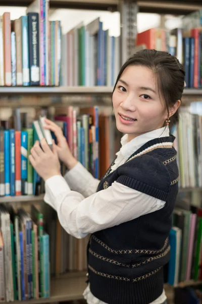 Портрет студента перед книжной полкой — стоковое фото