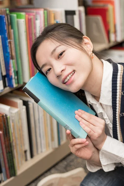 Girl hold a book against her face — Stock Photo, Image