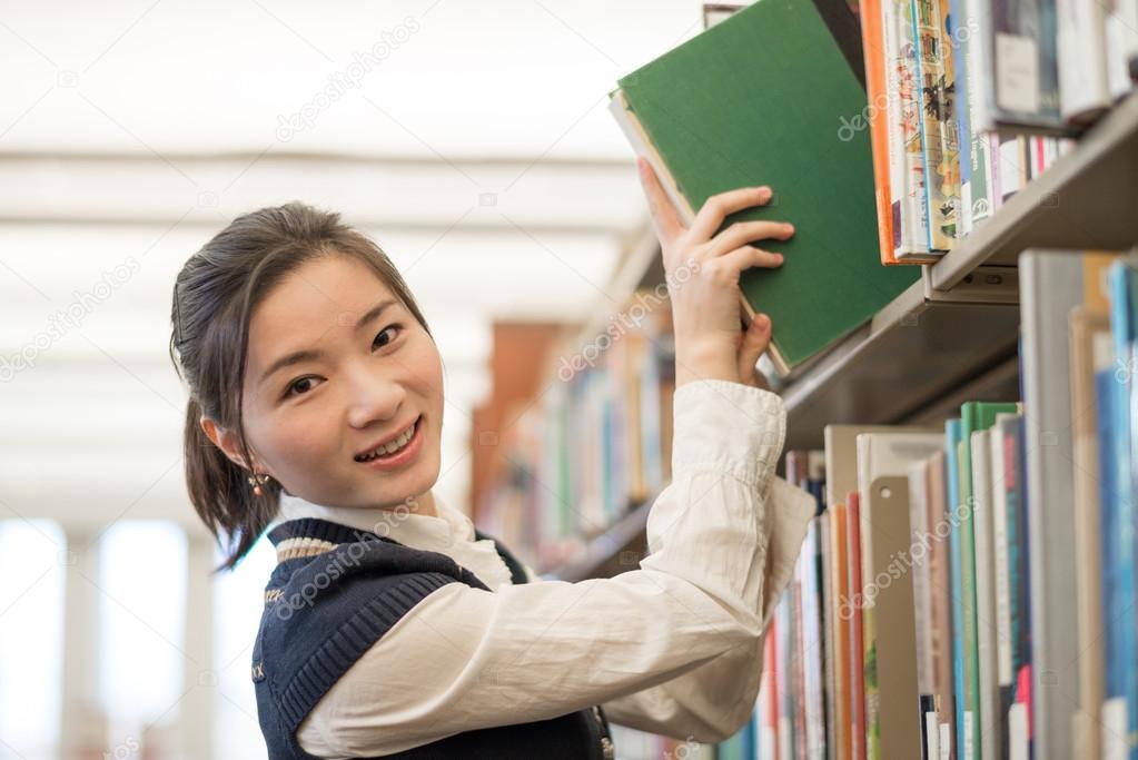 Woman taking a book from a bookshelf