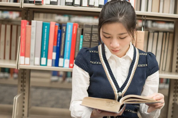 Fille assise sur le livre de lecture par terre — Photo