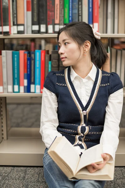 Studentin sitzt auf dem Boden und hält Buch — Stockfoto