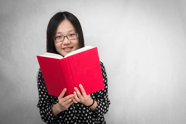 Tjej läser en röd bok — Stockfoto